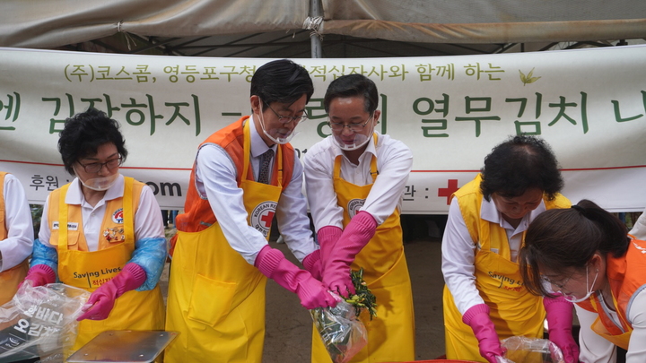 1일 문래텃밭에서 사랑의 열무김치 나눔 행사에 참석한 황선정 코스콤 전무이사(왼쪽에서 두번째)와 최호권 구청장(왼쪽에서 세번째)이 대한적십자사 봉사자들과 함께 김장을 하고 있다.(사진제공=코스콤) *재판매 및 DB 금지