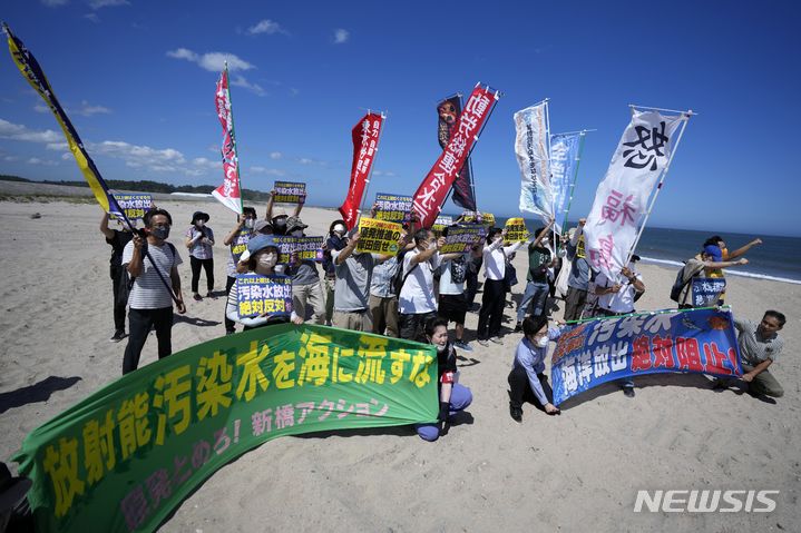 [도쿄=AP/뉴시스]지난 24일 일본 후쿠시마현 나미에마치의 해변에서 시민들이 후쿠시마 제1 원자력발전소 오염수 해양 방류 반대 시위를 벌이고 있다. 현수막에는 "방사능 오염수를 바다에 흘려보내지 말라!"고 적혀있다. 2023.08.25.