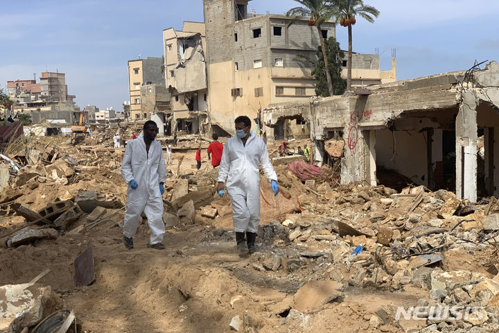 [데르나=AP/뉴시스] 대홍수 참사에서 살아남은 리비아 주민들이 식수 부족과 지뢰라는 새로운 생존 위협에 직면했다. 사진은 17일(현지시간) 리비아 데르나에서 구조대원들이 무너진 집터 사이를 수색하는 모습. 2023.09.18.