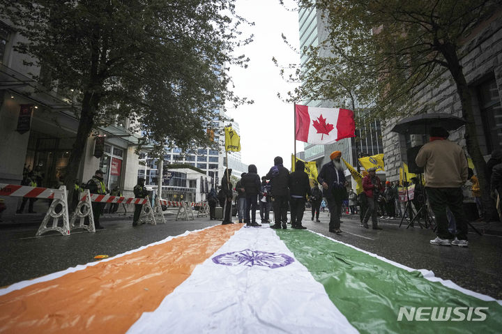[밴쿠버=AP/뉴시스]지난해 9월 25일(현지시각) 캐나다 브리티시컬럼비아주 밴쿠버에 있는 인도 총영사관 밖에서 캐나다 국기와 칼리스탄 깃발을 든 시크교도가 거리에 깔린 인도 국기를 밟으며 시위하고 있다. 시위대는 지난 6월 캐나다 국적 시크교도 지도자의 피살에 인도 정부가 개입했다는 캐나다 측 주장과 관련해 공개 조사를 요구하며 시위를 벌였다. 캐나다 경찰이 3일 살인 사건 용의자 3명을 체포했다고 발표했다. 2024.5.4.