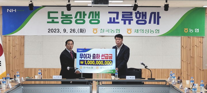 대구 칠곡농협 배상균 조합장(오른쪽)이 새의성농협 이재섭 조합장에게 무이자출하선급금을 전달하고 있다. *재판매 및 DB 금지