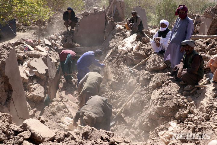 [제데흐잔=AP/뉴시스] 8일(현지시각) 아프가니스탄 헤라트주 제데흐잔에서 아프간 남성들이 지진 피해 희생자들을 찾고 있다. 탈레반 정부 대변인은 7일 헤라트주에 규모 6.3의 지진이 발생한 후 강한 여진이 여덟 차례 이어져 지금까지 최소 2000명이 숨졌다고 밝혔다. 2023.10.09.