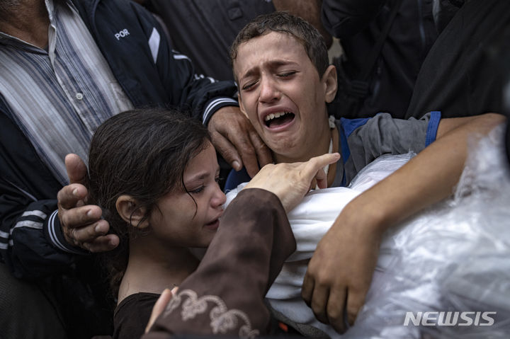 [칸유니스=AP/뉴시스] 지난달 14일(현지시각) 가자지구 칸유니스의 한 병원에서 팔레스타인 어린이들이 이스라엘 폭격으로 숨진 가족의 시신을 잡고 오열하는 모습. 2023.12.20.