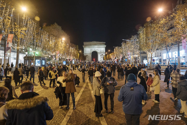 [파리=AP/뉴시스] 19일(현지시각) 프랑스 파리에서 크리스마스 시즌 샹젤리제 거리 점등식이 열려 시민들이 거리에 모여 있다. 2023.11.20.