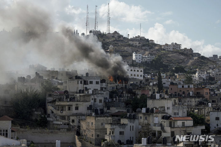 [제닌=AP/뉴시스] 13일(현지시각) 요르단강 서안지구 제닌에서 이스라엘군의 공격으로 불길과 연기가 치솟고 있다. 2023.12.13.