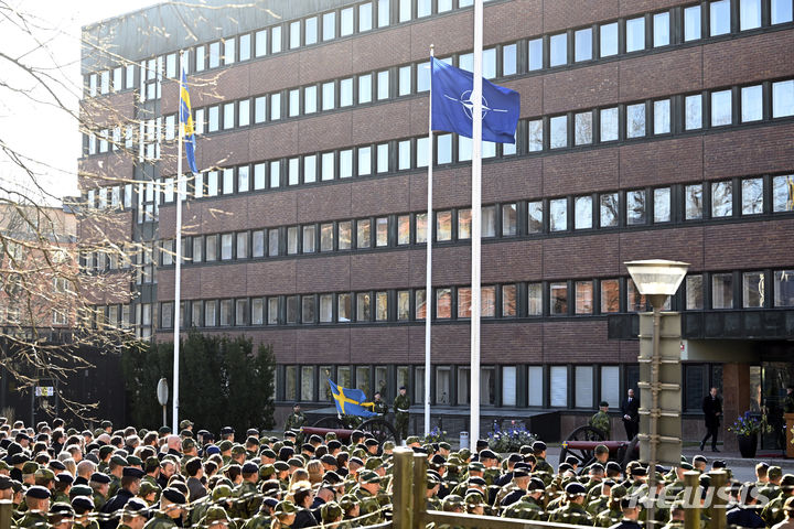 [스톡홀름(스웨덴)=AP/뉴시스]스웨덴 수도 스톡홀름의 국방부 앞에서 11일 열린 기념식에 스웨덴 국기(왼쪽)와 북대서양조약기구(나토) 깃발이 나란히 게양돼 있다. 스웨덴 국기가 11일 벨기에 브뤼셀의 북대서양조약기구(나토) 본부 밖에 게양됐다. 이로써 스웨덴은 나토의 32번째 동맹국으로서 입지를 굳혔다. 2024.03.11.