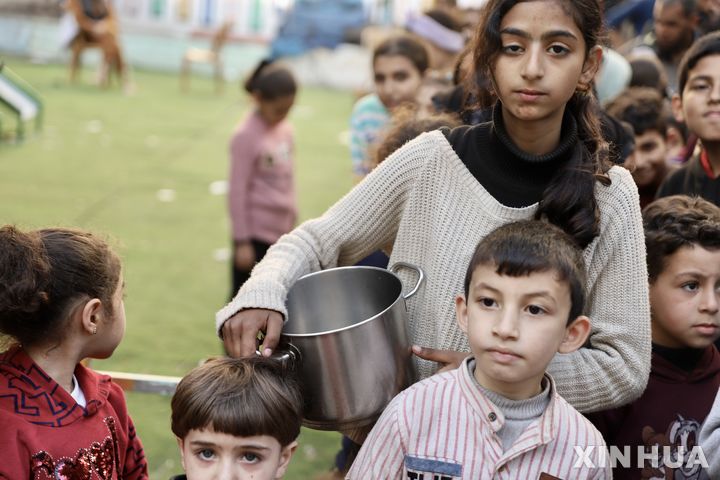 [가자시티=신화/뉴시스] 가자지구 가자시티에서 3월 13일 팔레스타인 어린이들이 라마단 동안의 구호 식량을 받기 위해 줄 서 있다. 유엔의 식량트럭이 이 지역에 들어와 4개월만에 밀가루가 배급된다고 유엔구호기관이 17일 발표했다. 2024.03.18.