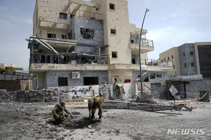 [AP/뉴시스] 27일 헤즈볼라의 보복 로켓이 이스라엘의 북부 시모나에 날아온 뒤 군인들이 조사하고 있다