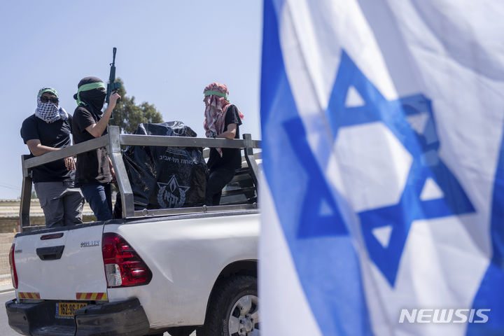 [예루살렘=AP/뉴시스] 하마스 무장세력의 복장을 한 이스라엘 시위대가 4월 3일(현지시각) 예루살렘에 있는 유엔 팔레스타인 난민구호기구(UNRWA) 본부 입구에서 시위하고 있다. 2024.05.10.