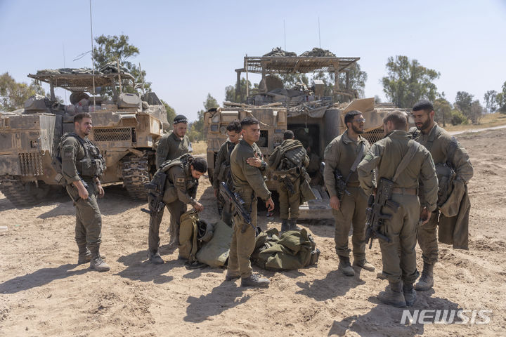 [가자지구=AP/뉴시스] 다니엘 하가리 이스라엘방위군(IDF) 대변인은 16일(현지시간) 이란에 대한 보복 의향을 거듭 밝혔다. 사진은 지난 15일 이스라엘 남부, 가자지구 국경 인근에 주둔 중인 이스라엘 군인들이 병력수송장갑차(APC) 주변에 모여 얘기를 나누고 있있는 모습. 2024.04.16.