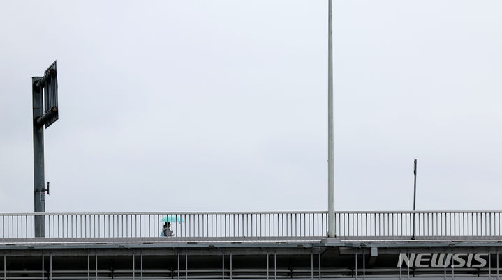 [대구=뉴시스] 이무열 기자 = 비가 내리는 15일 대구 북구 노곡교에서 우산을 쓴 한 학생이 이동하고 있다. 2024.04.15. lmy@newsis.com