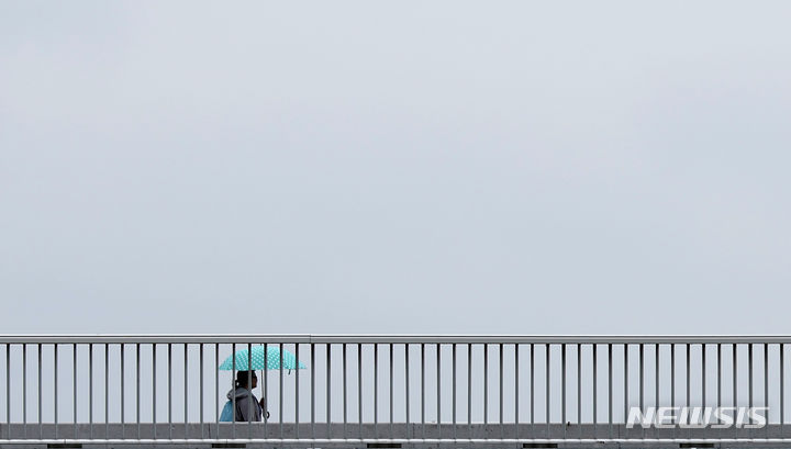 [대구=뉴시스] 이무열 기자 = 비가 내리는 지난 15일 대구 북구 노곡교에서 우산을 쓴 한 학생이 이동하고 있다. 2024.04.15. lmy@newsis.com