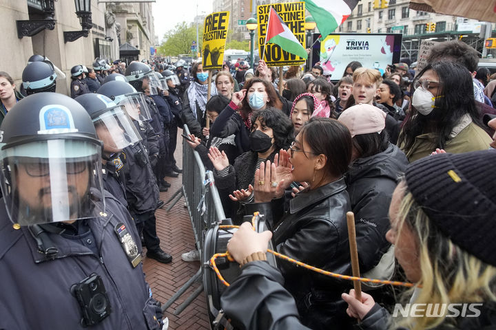[뉴욕= AP/뉴시스] 미 컬럼비아 대학교 캠퍼스의 팔레스타인 지지 시위대가 밖으로 쫒겨난 뒤 경찰에 맞서서 구호를 외치며 항의하고 있다. 2024.04. 19.  