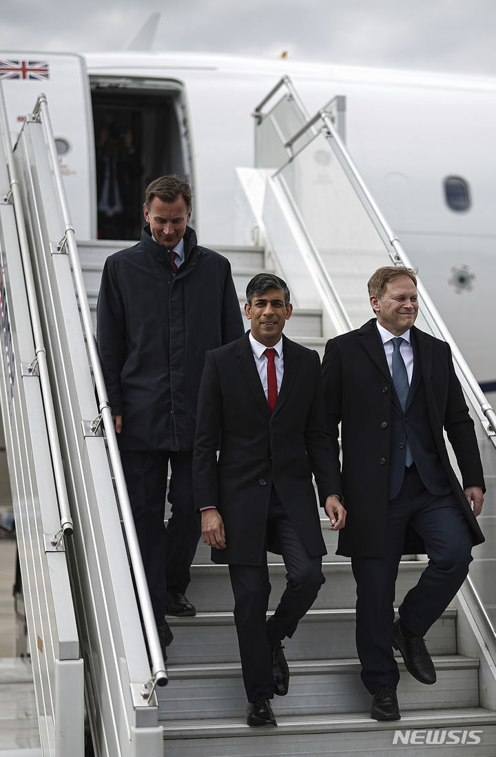 [AP/뉴시스] 23일 수낵 영국 총리가 폴란드 방문에 나서 제레미 헌트 재무장관(왼쪽) 및 그랜트 섑스 국방장관(오른쪽)과 함께 바르샤바 공항에 내리고 있다. 모두 집권 보수당 하원의원들이다. 