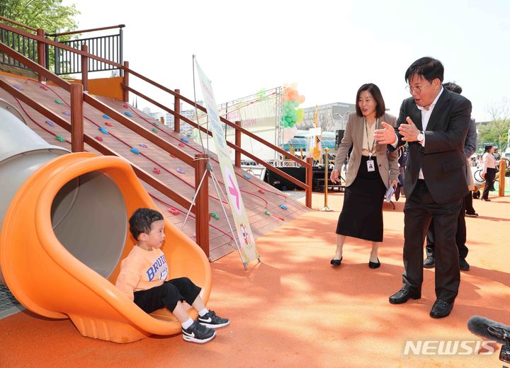 [서울=뉴시스]지난 23일 망원유수지 어린이체육센터에서 박강수 마포구청장이 슬라이드를 타는 어린이에게 박수를 보내고 있다.