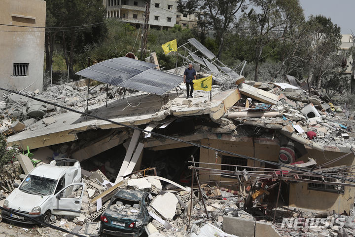 [하난(레바논)=AP/뉴시스]레바논 남부 하난 마을에서 25일 한 남성이 이스라엘군의 공습으로 파괴된 집 위에 서 있다. 레바논의 무장단체 헤즈볼라가 국경 분쟁지역의 이스라엘군 호송차량을 향해 대전차 미사일과 포탄을 발사, 이스라엘 민간인 1명이 사망했다고 헤즈볼라와 이스라엘군이 26일 밝혔다. 2024.04.26.