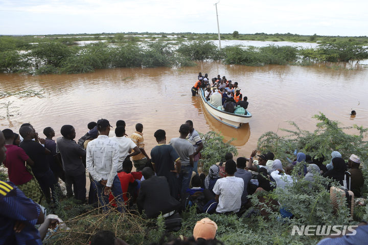 [모로로=AP/뉴시스] 28일(현지시각) 케냐 북동부 타나강과 가리사 카운티의 경계인 모로로에서 주민들이 배를 타고 침수 구역을 빠져 나오고 있다. 2024.04.29.