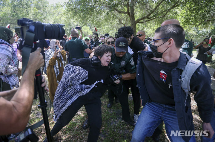 [탬파=AP/뉴시스] 4월29일 미 플로리다주 탬파의 사우스플로리다 대학교에서 친팔레스타인 시위대가 경찰과 충돌하는 동안 한 시위 참가자가 경찰에 끌려가고 있다. 2024.05.06.