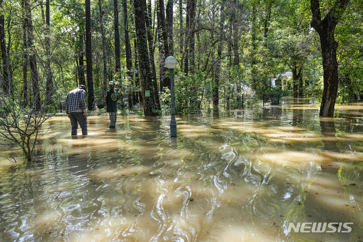 [휴스턴( 미 텍사스주)=AP/뉴시스] 텍사스주 휴스턴 일대의 홍수로 2일 숲길이 강물로 변해 가는 콘로 일대의 숲에서 주민들이 도보로 대피하고 있다. 2024. 05. 03. 