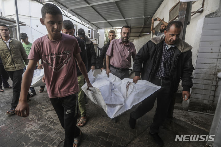 [AP/뉴시스] 3일 가자 팔레스타인 주민들이 전날 밤 라파 공습에 사망한 가족 시신을 옮기고 있다. 차히네 가족으로 어른 2명과 16세 미만 5명이 죽었다. 