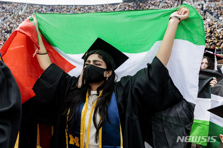 [앤아버=AP/뉴시스] 4일(현지시각) 미국 미시간주 앤아버에서 열린 인디애나대 졸업식에서 한 졸업생이 학사모를 쓰고 팔레스타인 깃발을 들고 반전시위를 벌이고 있다. 2024.05.05