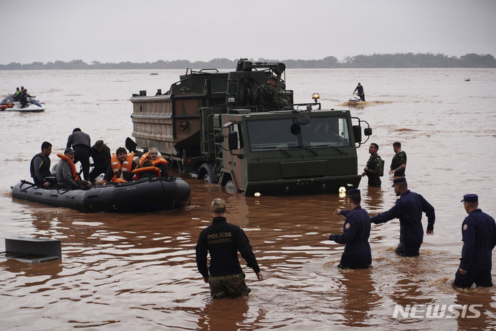 [포르투알레그레( 브라질)= AP/뉴시스] 브라질 군인들이 주말인 5월 4일 포르투 알레그레에서 심한 폭우로 수몰된 지역의 주민들을 구조하고 있다. 2024. 05. 06. 