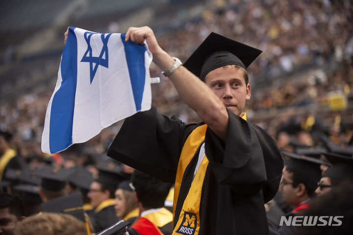 [앤아버=AP/뉴시스] 4일(현지시각) 미국 미시간주 앤아버에서 열린 인디애나대 졸업식에서 가자 반전 시위가 열린 가운데 한 졸업생이 이스라엘 국기를 들고 친이스라엘 입장을 밝히고 있다. 2024.05.05