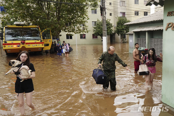 [리우그란데두술=AP/뉴시스] 4일(현지시각) 브라질 남부 리우그란데두술주 카노아스의 홍수 피해 지역에서 주민들이 대피하고 있다. 2024.05.07.