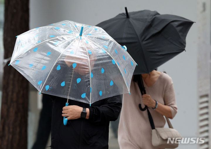 [서울=뉴시스] 추상철 기자 = 화요일인 7일은 전국 대부분 지역에 가끔 비가 내리겠으나 대부분 소강 상태를 보이겠다. 사진은 비가 내린 지난 6일 오후 서울 중구 세종대로 사거리 인근에서 우산을 쓴 시민이 우산으로 바람을 막으며 발걸음을 옮기는 모습. 2024.05.06. scchoo@newsis.com