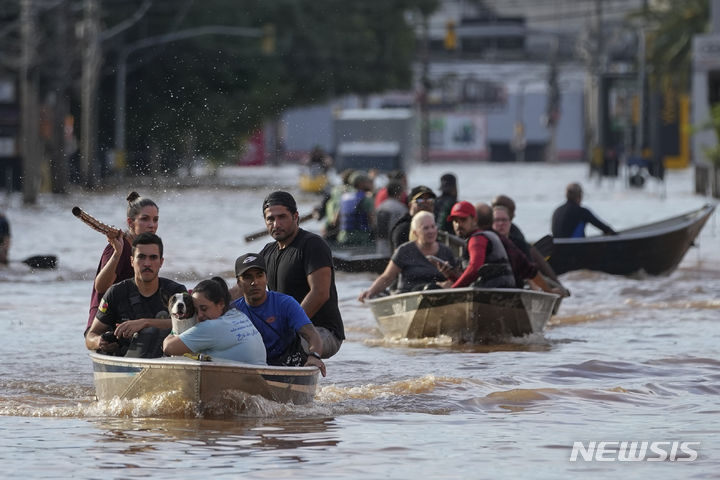 [포르투알레그리=AP/뉴시스] 브라질 남부 히우그랑지두술주에 폭우와 홍수가 발생해 7일(현지시각) 포르투알레그리에서 자원봉사자들이 침수 지역 주민들을 배에 태워 대피시키고 있다. 2024.05.09.