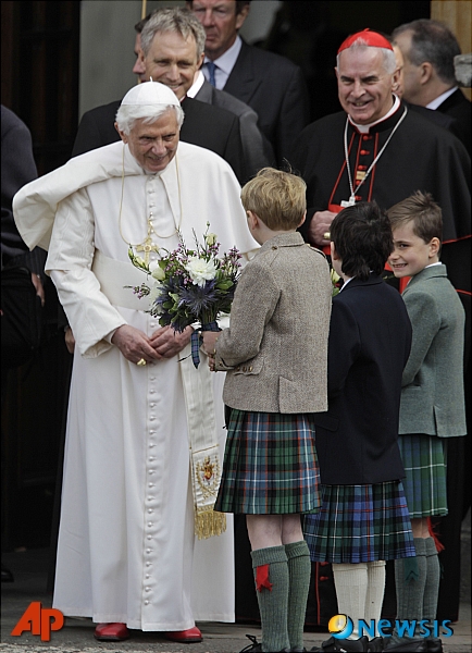 【에든버러(영국)=AP/뉴시스】영국을 방문한 교황 베네딕트 16세(왼쪽)가  지난 2010년 9월16일(현지시간) 영국 스코틀랜드의 에든버러 소재 홀리루드 하우스 궁전에서 엘리자베스 2세 영국 여왕과 걸어나오면서 어린이들로부터 꽃다발을 받고 있다.. 2020.08.04