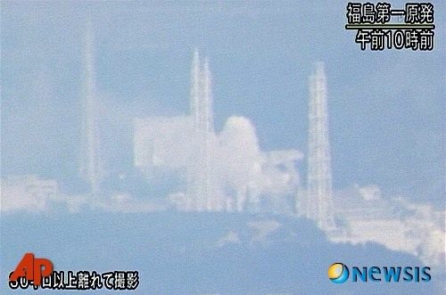 【오쿠마마치(일본)=AP/뉴시스】일본 동북부 강진 엿새째인 16일 아침 NHK 방송은 후쿠시마현 오쿠마마치의 후쿠시마 다이이치 원전에서 하얀 연기가 치솟는 모습을 방영했다. NHK 방송은 자세한 사항은 촬영시간 현재까지 알려진 바 없다고 밝혔으며 화면 하단에는 이 영상이 30km 밖에서 촬영된 것이라 밝히고 있다.