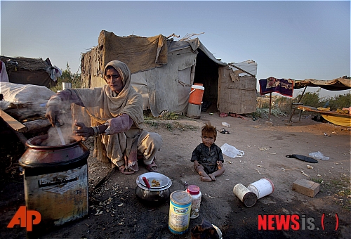 【이슬라마바드=AP/뉴시스】세계 빈곤 퇴치의 날인 지난 2011년 10월17일, 파키스탄 빈민촌에 거주하는 한 여성이 식사를 준비하는 동안 옆에서 어린 아들이 놀고 있다. 세계은행은 20일 지난 2015년 19억명에 달했전 전세계 극빈곤 인구가 2015년 7억3600만명으로 10억명 이상 감소했다고 밝혔다. 2018.9.20