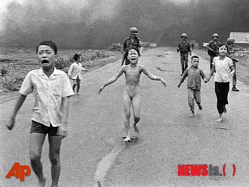 【짱방(베트남)=AP/뉴시스】지난 1972년 6월8일 베트남 남부 짱방 지역 인근 1번 도로에서 당시 9세인 소녀 킴 푹을 포함해 아이들이 울면서  뛰어가고 있다. 네이팜탄이 떨어지면서 불길이 옷에 옮아붙자 푹은 옷을 벗어 버리고 뛰어갔고, 그는 훗날 '네이팜탄 소녀'로 불렸다. 한편 AP통신의 후잉 콩 우트 기자가 찍은 이 사진은 베트남 전쟁을 참혹함을 그려 퓰리처상을 받았다.