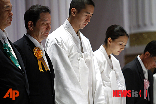 The Rev. Hyung-jin Moon, third from left, the youngest son of the late Rev. Sun Myung Moon, bows with mourners during a memorial service for his father and the founder of the Unification Church at the Cheong Shim Peace World Center in Gapyeong, South Korea, Sunday, Sept. 9, 2012. (AP Photo/Hye Soo Nah)
