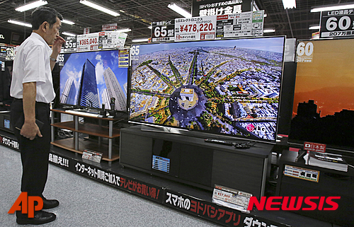 【도쿄=AP/뉴시스】지난 6월26일 일본 도쿄에서 한 일본 남성이 LG 4K 울트라 티비를 구경하고 있다. 최근 일본 경제 회복은 불투명한 상황에 있다. 2015.08.17