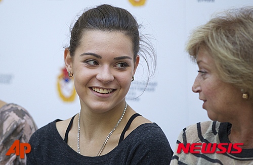 Olympic figure skating champion Adelina Sotnikova, left, speaks with her coach Yelena Vodorezova-Buianova after her first open training session this year in Moscow, Russia, Thursday, Aug. 20, 2015. (AP Photo/Pavel Golovkin)