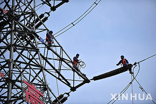 【톈진=신화/뉴시스】 지난 2015년 8월 24일 톈진시에서 전력공사 직원들이 고공에서 전력망 연결 작업을 진행하는 모습. 