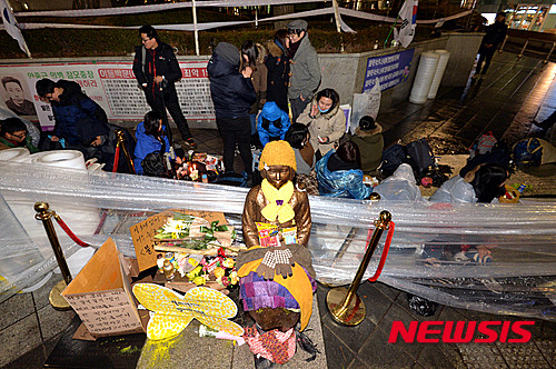 [서울=뉴시스] 2015년 마지막 수요시위가 열린 30일 저녁 서울 종로구 중학동 일본대사관 앞 소녀상 곁에서 열린 '일본군 위안부 문제 한·일 협상안 폐기'를 촉구하는 촛불문화제를 끝낸 대학생들이 밤샘 연좌농성을 하고 있다. 2015.12.30. (사진=뉴시스 DB)