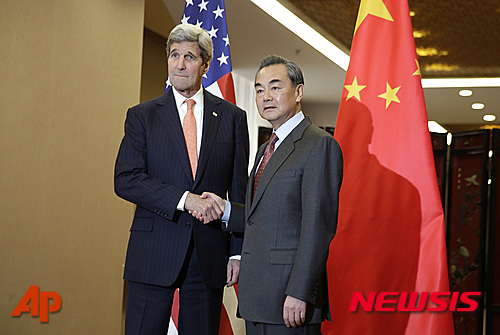 【베이징=AP/뉴시스】존 케리 미국 국무장관(왼쪽)이 27일 중국 베이징에서 왕이 외교부장과 회담 전 악수하고 있다. 2016.01.27  