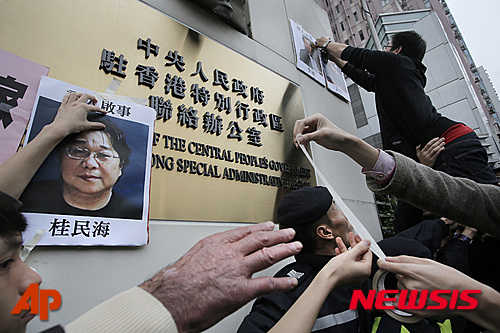 【홍콩=AP/뉴시스】홍콩의 민주화를 요구하는 시위대가 지난 1월 3일 홍콩 내 중국 정부 연락사무소에 실종된 출판인, 서점인 사진을 붙이며 사건 규명을 촉구하는 시위를 벌이고 있다. 지난해 12월 말부터 실종됐던 5명은 지난 2월 28일과 29일 연이어 TV 인터뷰를 갖고 일부 불법행위를 시인하는가 하면 중국 당국에 의한 납치를 부인했다. 2016.03.02 