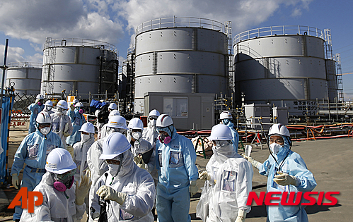 【오쿠마=AP/뉴시스】2016년  2월 10일 보호복을 입은 기자들이 후쿠시마현 오쿠마에 있는 도쿄전력 원전의 방사성 물질 오염수 저장시설을 살펴보고 있다. 2016.03.08