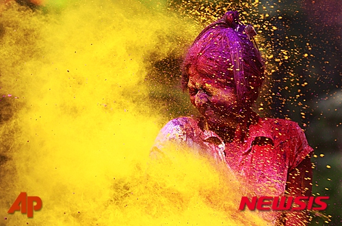 【뭄바이=AP/뉴시스】인도 뭄바이에서 24일 힌두교도들의 홀리축제를 맞아 한 여성이 노란색 가루 세례를 받자 얼굴을 찡그리고 있다. 홀리 축제는 인도의 3대 축제 중 하나로 색색의 가루나 물감을 뿌리며 즐긴다. 2016.03.25  