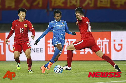 China's Jiang Ning, left, and Huang Bowen, right, fight for the ball against Maldives' Fasir, center, during their 2018 World Cup Asian qualifying soccer match in Wuhan in central China's Hubei province, Thursday, March 24, 2016. China beat Maldives 4-0. (Color China Photo via AP)   CHINA OUT