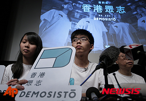 【홍콩=AP/뉴시스】지난 2014년 홍콩 민주화운동인 '우산혁명'을 이끈 학생 리더인 조슈아 웡(20) 등 주역들이 새로운 정당을 창설했다. 10일 이들은 기자회견을 열어 '데모시스토(Demosisto·香港衆志)'를 공식 창설한다고 밝혔다. 그리스어로 '인민'이라는 뜻의 데모(Demo)와 라틴어의 일어나다라는 뜻의 '시스토'를 결합해 만든 이 정당의 '민주를 위해 일어선다'라는 뜻을 담고 있다. 사진은 조슈아 웡이 새 정당 로고를 들고 있는 모습. 2016.04.11 