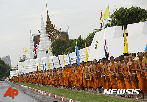 【방콕=AP/뉴시스】태국 불교 승려들이 9일 푸미폰 아둔야뎃 국왕 즉위 70년을 맞아 방콕 왕궁 앞에서 줄지어 탁발을 하고 있다.  2016.06.09