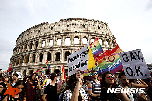 【로마=AP/뉴시스】11일(현지시간) 이탈리아 로마에서 성소수자들의 권리를 주장하는 축제인 ‘게이 프라이드 행진’(Gay Pride Parade)이 열렸다. 사진은 행진 참가자들이 성소수자를 상징하는 무지개색 깃발을 들고 로마의 콜로세움 옆을 지나가는 장면. 2016.06.12.