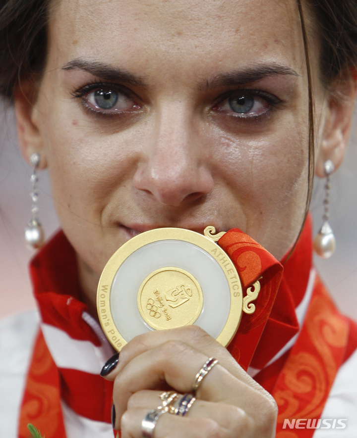 [베이징=AP/뉴시스] 러시아 장대 높이뛰기 선수 옐레나 이신바예바가 2008년 8월19일 베이징올림픽 시상식에서 금메달을 들어 보이고 있다.