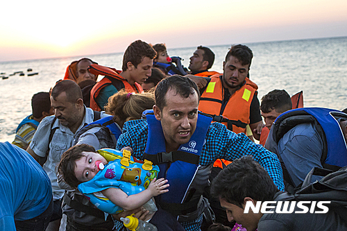 【코스=AP/뉴시스】2015년 8월 13일 터키로부터 그리스의 코스 섬으로 가던 난민선에서 구조한 난민들 중 한 남자가 여자 아기를 안고 있는 모습. 19일 유엔에서는 난민문제를 논의하기 위한 정상회의가 개최된다. 2016.09.19 