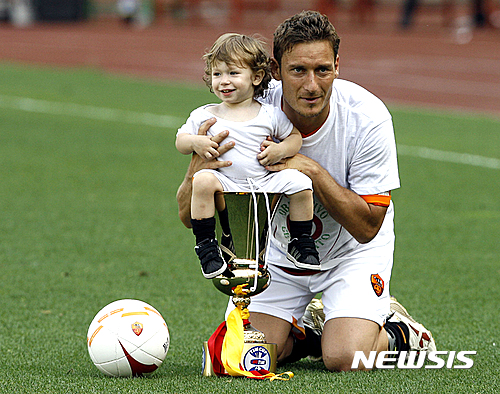 FILE - In this May 27, 2007 file photo, Roma's Francesco Totti poses for photographers with his son Cristian and the Italian Cup trophy at the end of the Italian top league soccer match between AS Roma and Messina at Rome's Olympic Stadium. Totti celebrates his 40th birthday on Tuesday, Sept. 27, 2016, but is showing no signs of slowing down and indeed seems to have found a new lease of life. He may not be Roma's 'Golden Boy' anymore but he is still very much 'the King of Rome.' (AP Photo/Alessandra Tarantino)
